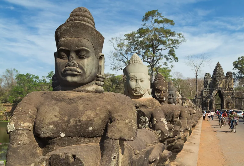 A row of stone guardian statues lines the causeway to the South Gate of Angkor Thom in Siem Reap.