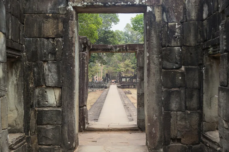 A stone doorway frames a long causeway leading through Baphuon temple in Angkor Thom, Siem Reap.