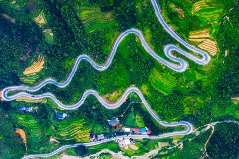 Aerial view of a winding mountain road curving through green hillsides near Cao Bang.