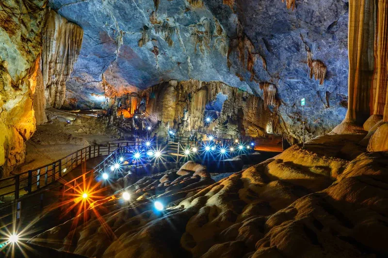 Illuminated stalactites and a wooden walkway light up the vast interior of Paradise Cave in Vietnam.