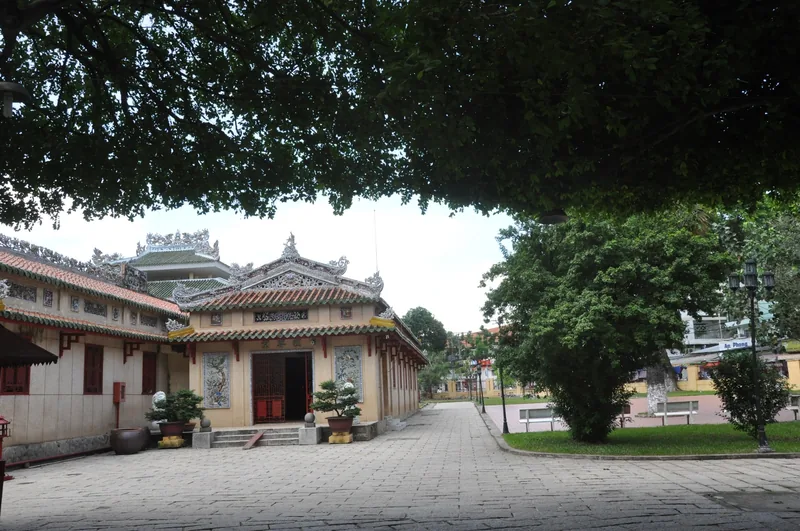 Traditional Chinese-style temple building with ornate roof carvings at Lang Ong shrine in Ho Chi Minh City.
