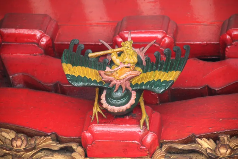 A colorful painted figure riding a phoenix decorates the red tiled roof of Ha Chuong Hoi Quan pagoda in Ho Chi Minh City.