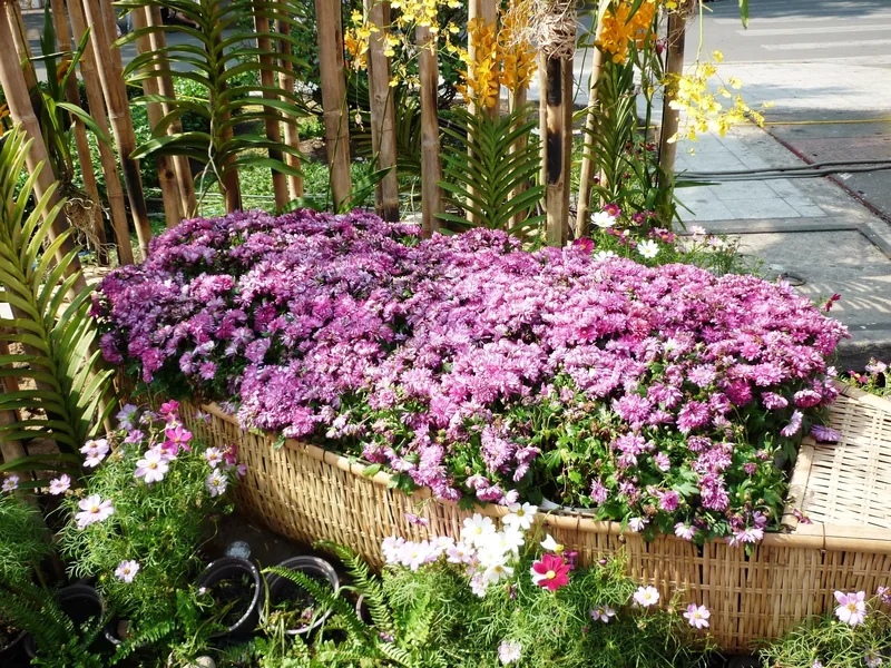 A woven basket boat filled with pink chrysanthemums decorates a street display in Ho Chi Minh City.