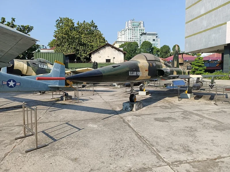 Vintage US Air Force fighter jets displayed outdoors at a war museum courtyard in Saigon.