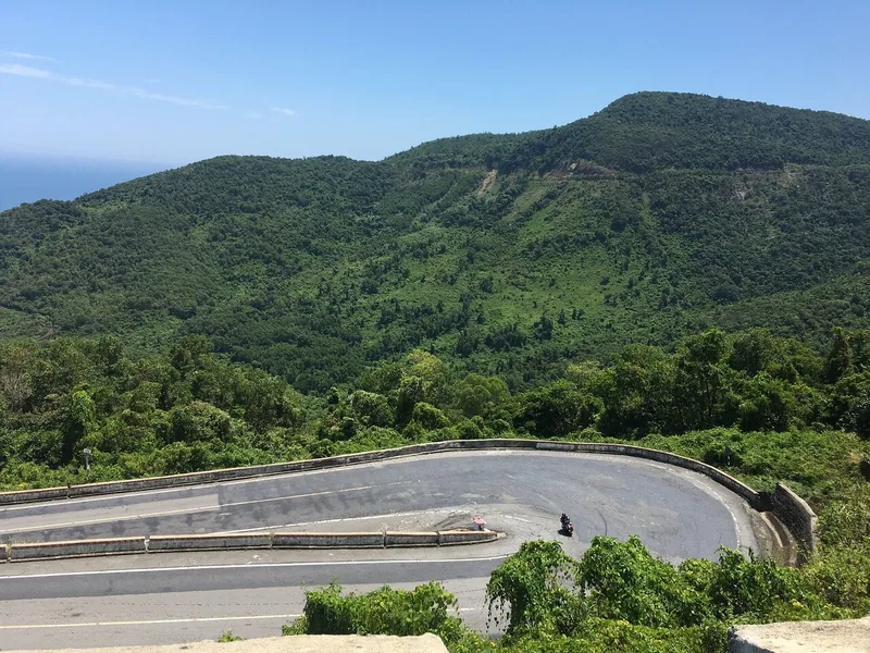 A motorbike navigates a hairpin curve on the mountain pass road between Hue and Hoi An.