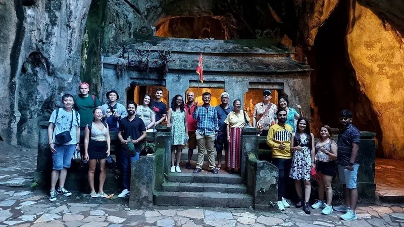 A group of tourists poses for a photo at a shrine inside a cave at Marble Mountains near Da Nang.