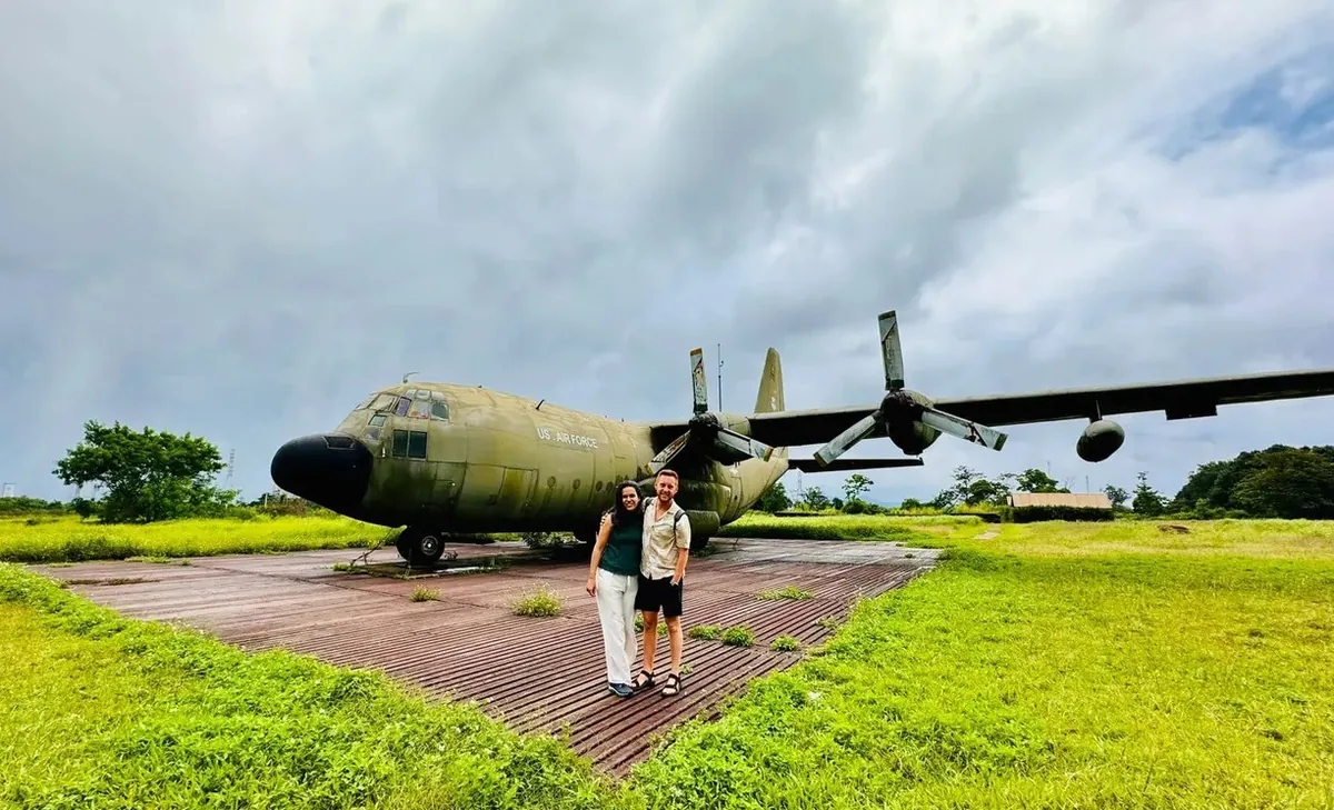 Tourists pose beside an abandoned US Air Force cargo plane at a former airbase near Hue.