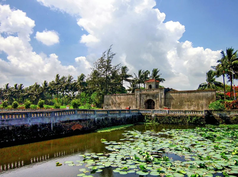 An ancient stone gate and moat covered with lotus leaves at Quang Tri Ancient Citadel