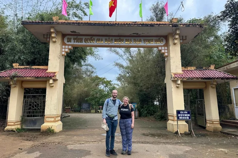 Two visitors pose beneath the entrance gate of Vinh Moc Tunnels national relic site near Hue.