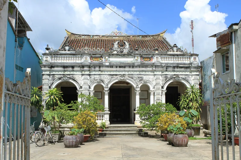 An ornate ancestral hall with intricate stone carvings and arched doorways in Dong Thap, Vietnam.