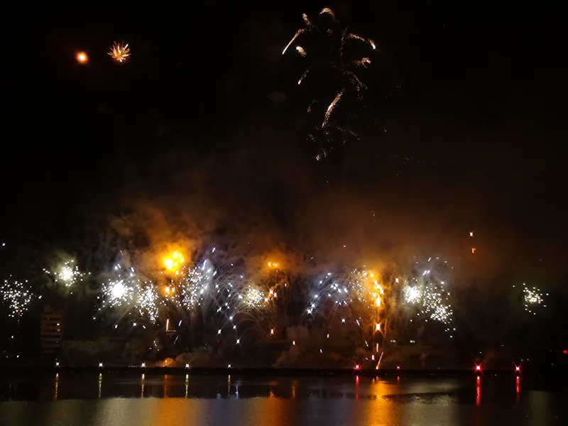 Fireworks burst over a river during the Da Nang International Fireworks Festival at night