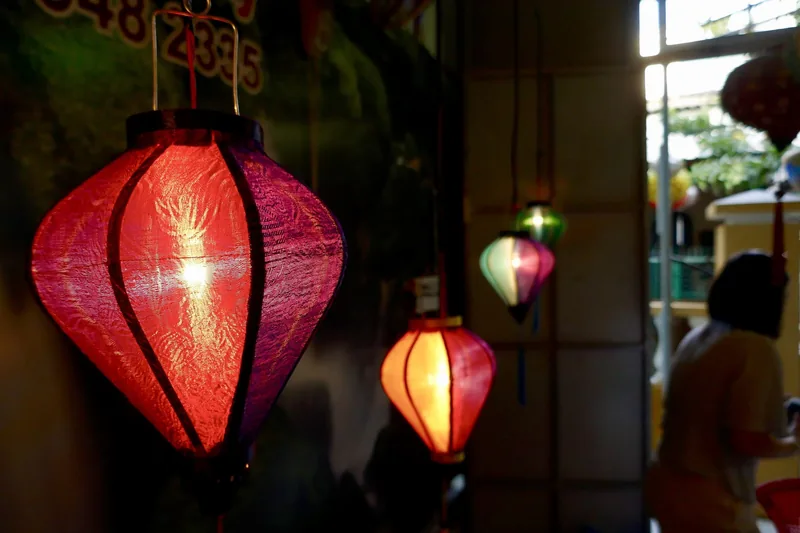 Colorful silk lanterns glow inside a shop in Hoi An's old town.