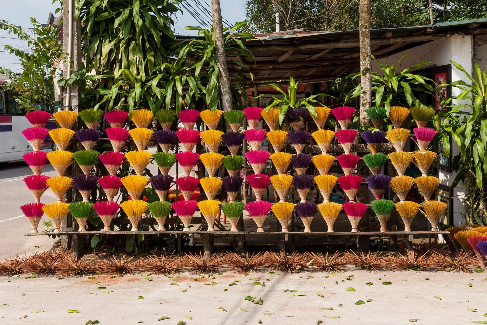 Bundles of colorful dyed incense sticks fan out on display racks near a tomb site in Hue, Vietnam.