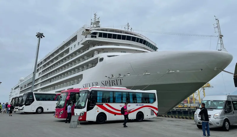 The cruise ship Silver Spirit docked at port with tour buses lined up for passengers in Vietnam.