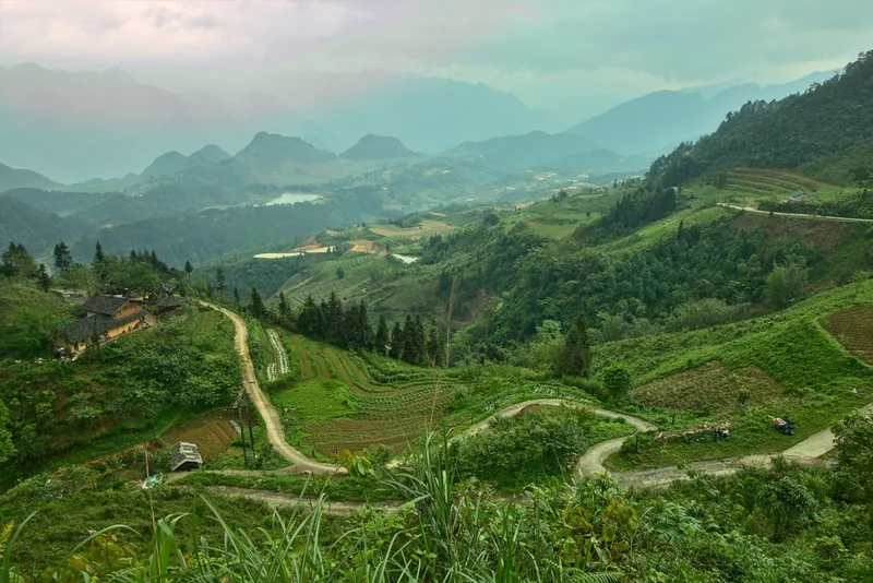 Winding roads cut through terraced fields and misty mountains in Quan Ba, Ha Giang province