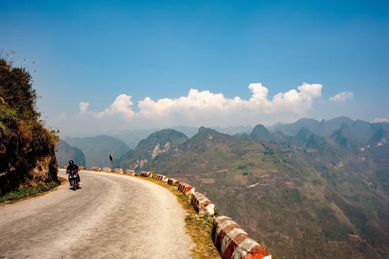 A motorcyclist rides along the winding mountain road of Ma Pi Leng Pass in Ha Giang.