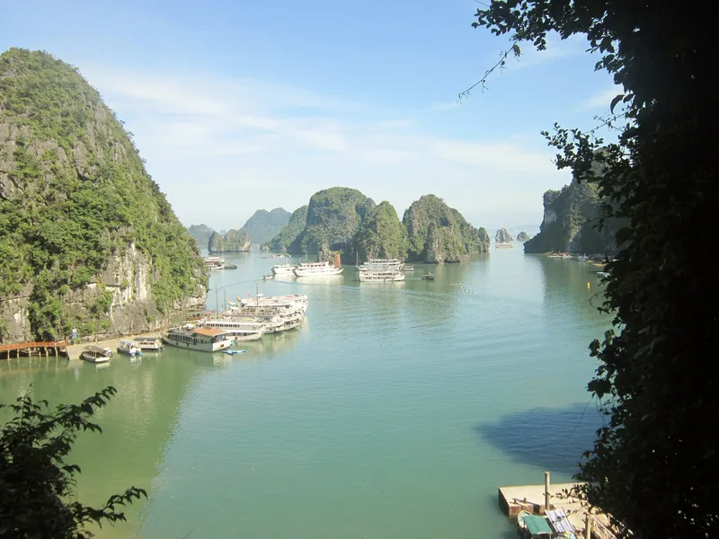 Cruise boats anchor among limestone karst islands in Ha Long Bay, Vietnam.
