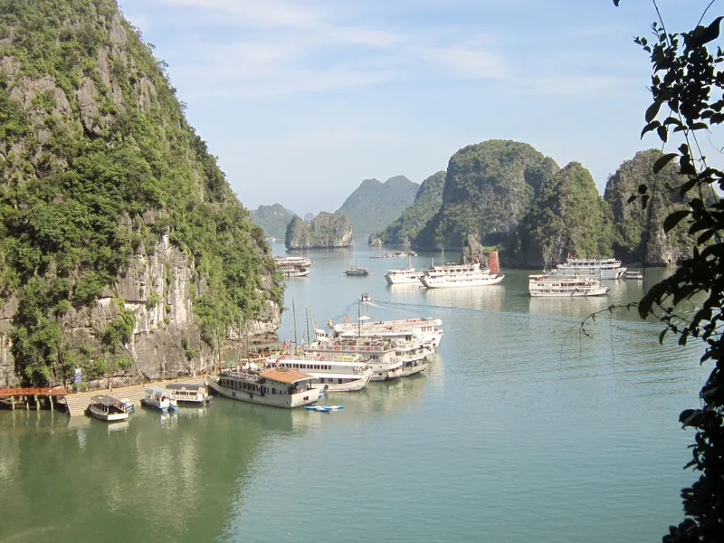 Cruise boats anchored among limestone karsts in Ha Long Bay, Vietnam.