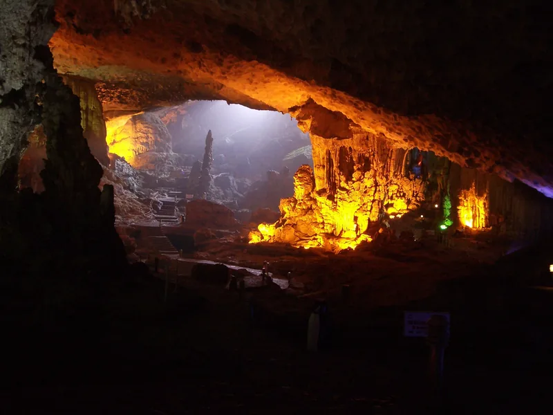 Colorful lit stalactites and rock formations inside a cave in Ha Long Bay, Vietnam.