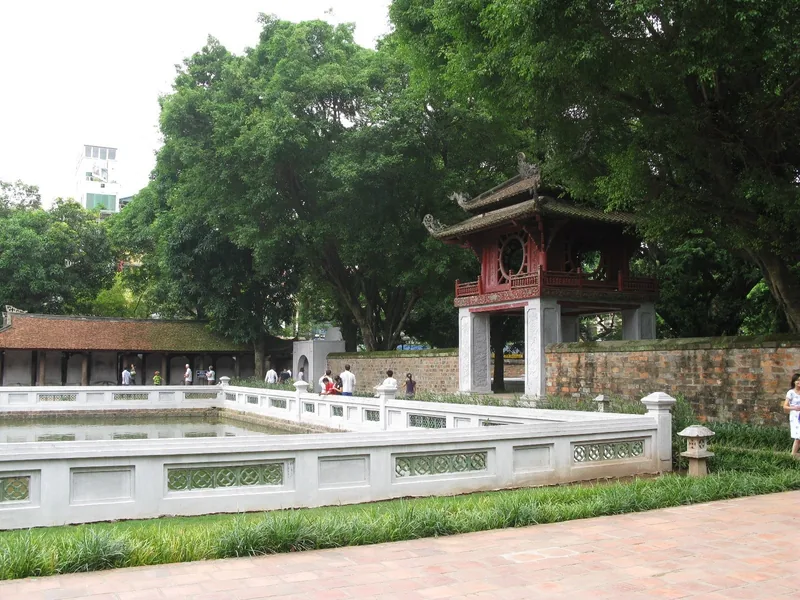 The red Khue Van Cac pavilion stands beside a stone-walled pond at the Temple of Literature in Hanoi.