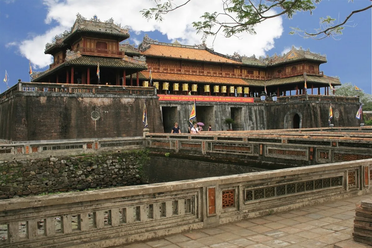 Ornate tiered gate towers rise above the stone walls and moat of Hue's Imperial City citadel.