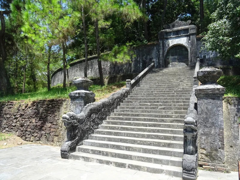 Stone staircase with dragon balustrades leads up to a gate at the Tomb of Emperor Minh Mang in Hue.