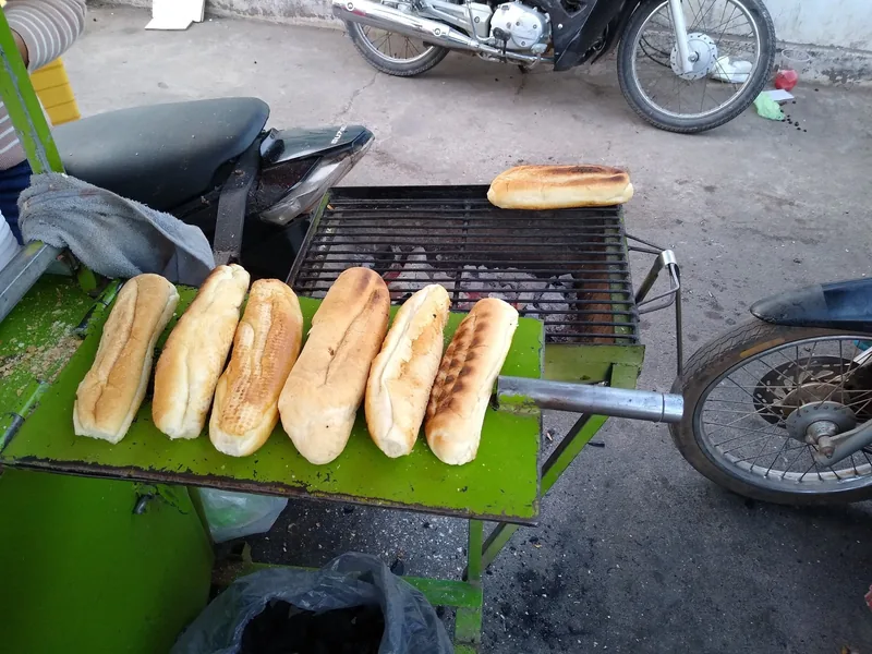 Fresh baguettes toast over charcoal on a street cart grill in Kampot.