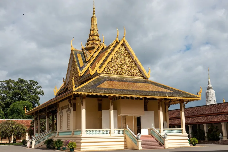 A gilded pavilion with tiered ornate roofs stands within the Royal Palace complex in Phnom Penh.