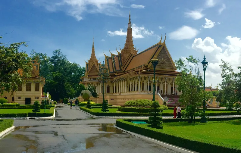 The Throne Hall's spired golden roof rises above manicured gardens at the Royal Palace in Phnom Penh.