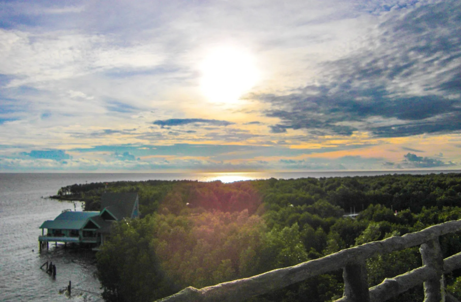Sun setting over the sea and mangrove forest viewed from a lookout tower at Mui Ca Mau, Vietnam's southernmost point.