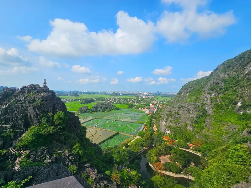 A pagoda-topped peak overlooks green rice fields and limestone karsts at Hang Múa in Ninh Bình.