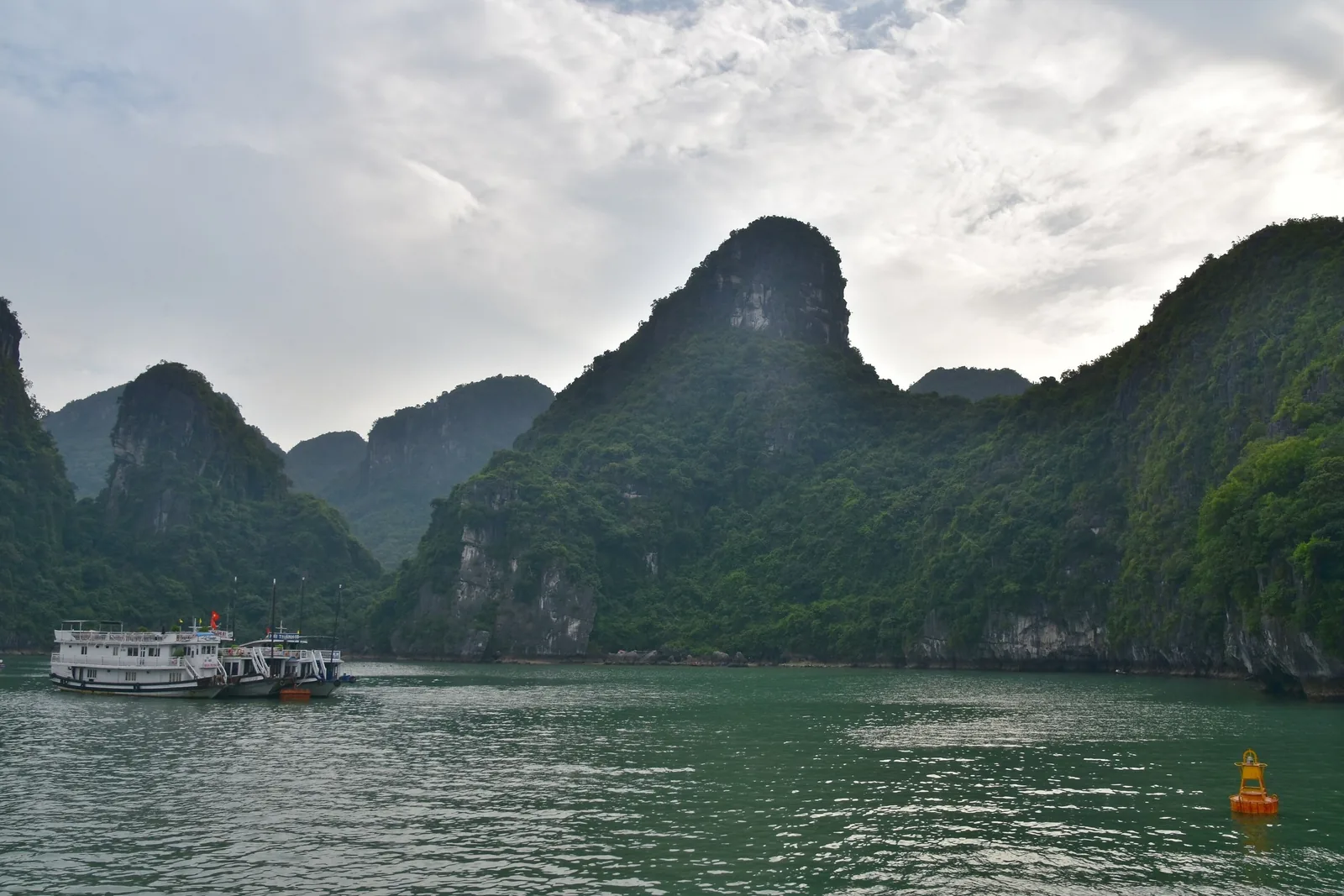 Cruise boats float near towering limestone karsts in Ha Long Bay, northern Vietnam.