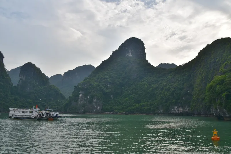 Cruise boats float near towering limestone karsts in Ha Long Bay, northern Vietnam.