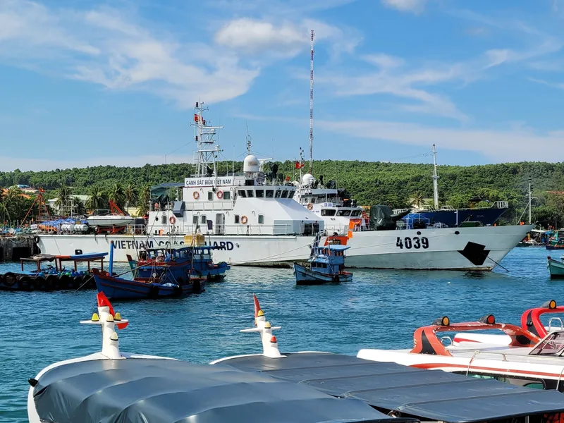A Vietnam Coast Guard patrol vessel docked among fishing boats in a Phu Quoc harbor.