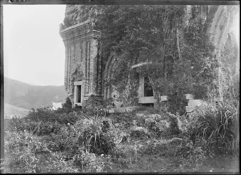 Vine-covered brick Cham towers stand in ruins on a hillside near Quy Nhon in this old black-and-white photograph.