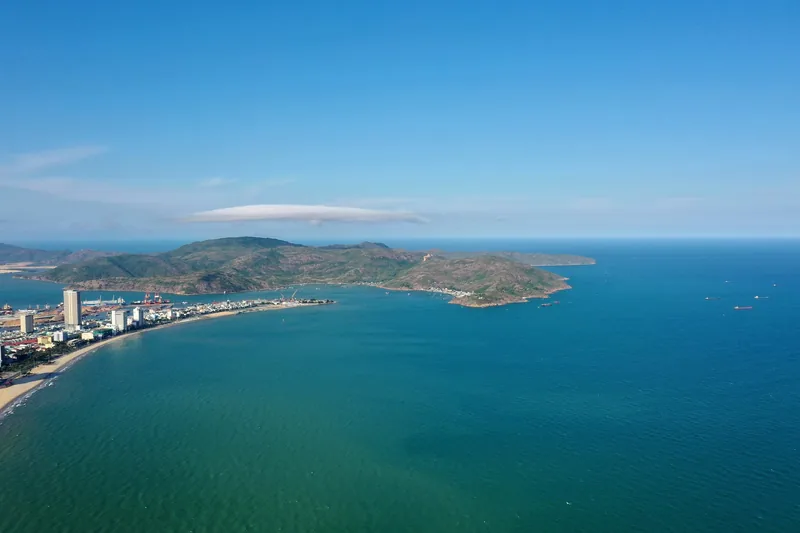 Aerial view of Quy Nhon's coastline with the Phuong Mai peninsula stretching into the blue sea.