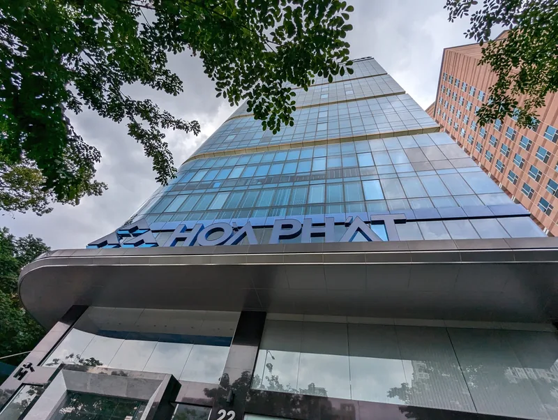 A glass office tower with the Hoa Phat sign viewed from below in Ho Chi Minh City's District 1.