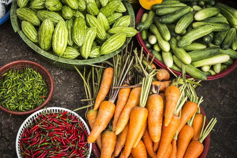 Baskets of bitter melon, cucumbers, carrots and chilies at a Ho Chi Minh City market