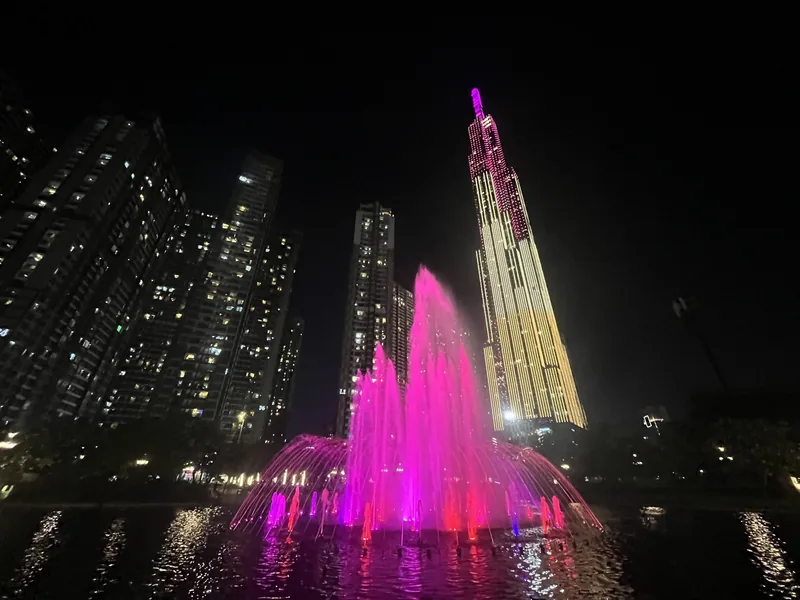 A pink illuminated fountain glows at night in front of the Landmark 81 skyscraper in Ho Chi Minh City.