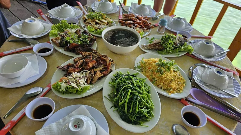 A seafood feast of crab, fried rice, morning glory and soup spread across a table by the water in Nha Trang.