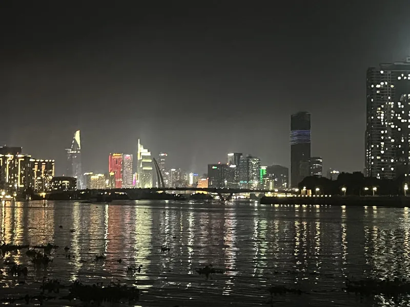 City skyline of Ho Chi Minh City glows at night, reflected in the Saigon River.