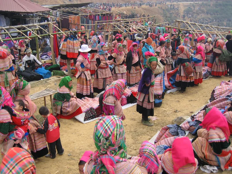 Hill tribe women in colorful traditional dress gather at Can Cau market near Sapa