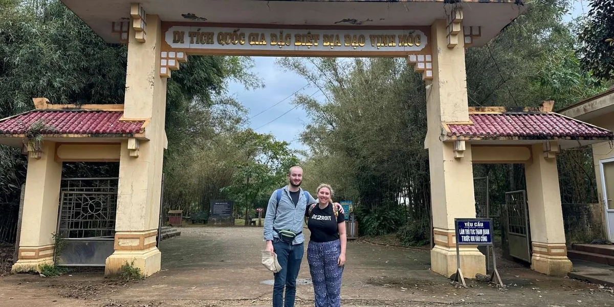 A couple poses at the yellow gate entrance to Vinh Moc Tunnels national relic site near Hue.