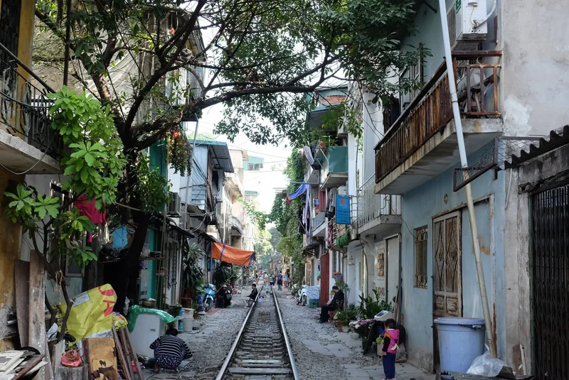 Narrow train tracks run through Hanoi's famous Train Street, lined with close-set houses and daily street life.