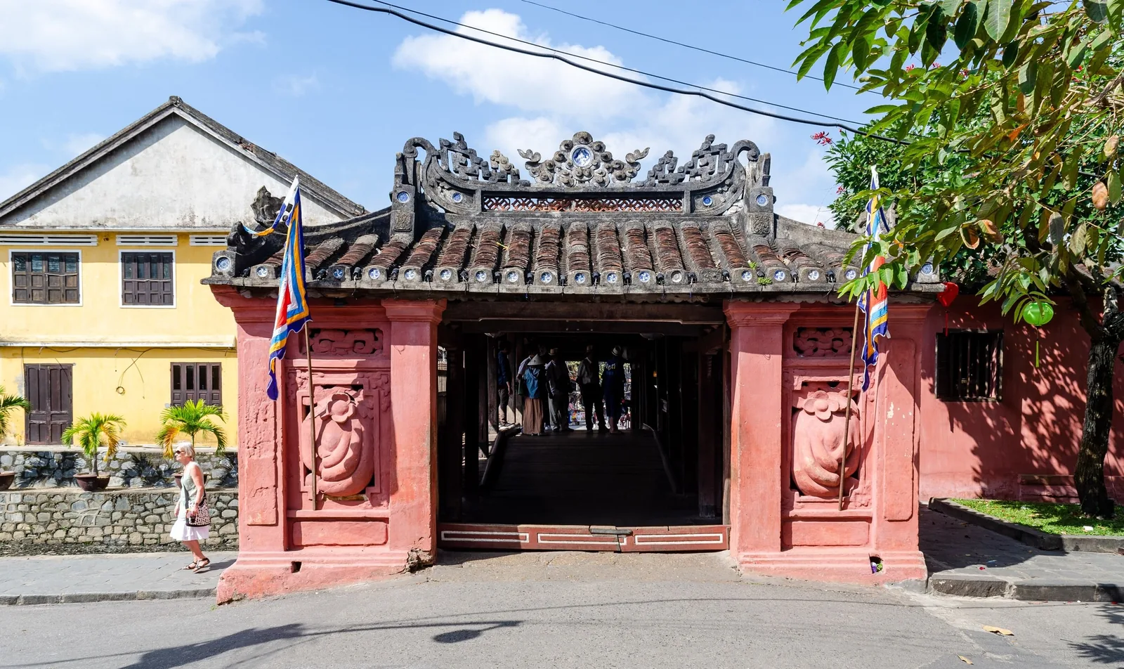 The tiled roof and pink gate of the Japanese Covered Bridge welcome visitors in Hoi An's old town.