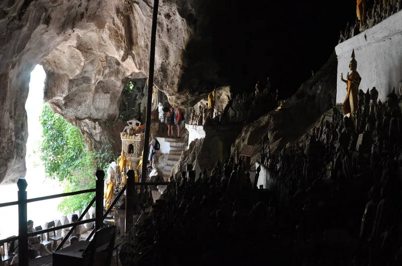Rows of small Buddha statues line the rocky walls inside Pak Ou Caves near Luang Prabang.