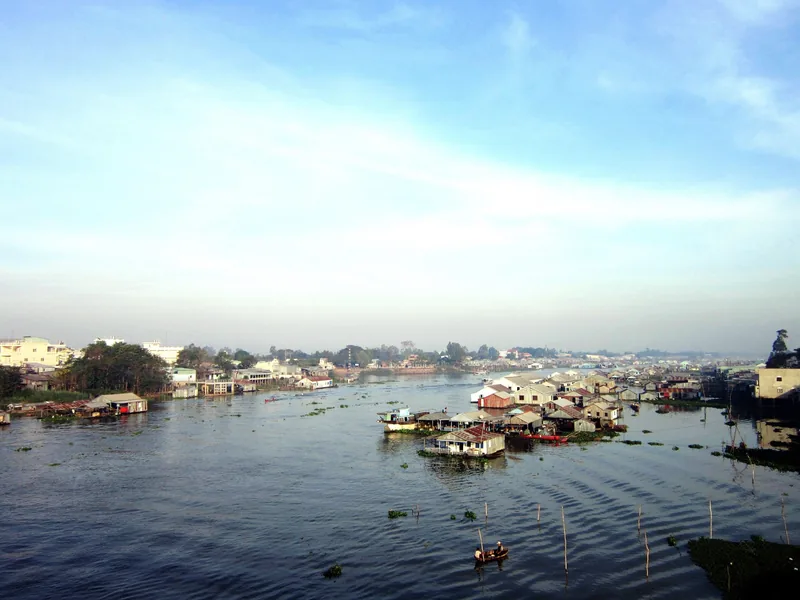 Floating houses line the wide river at Chau Doc under a pale morning sky.